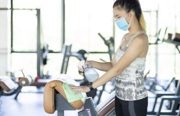 Sales and marketing woman wearing mask cleaning gym equipment Freepik stock column